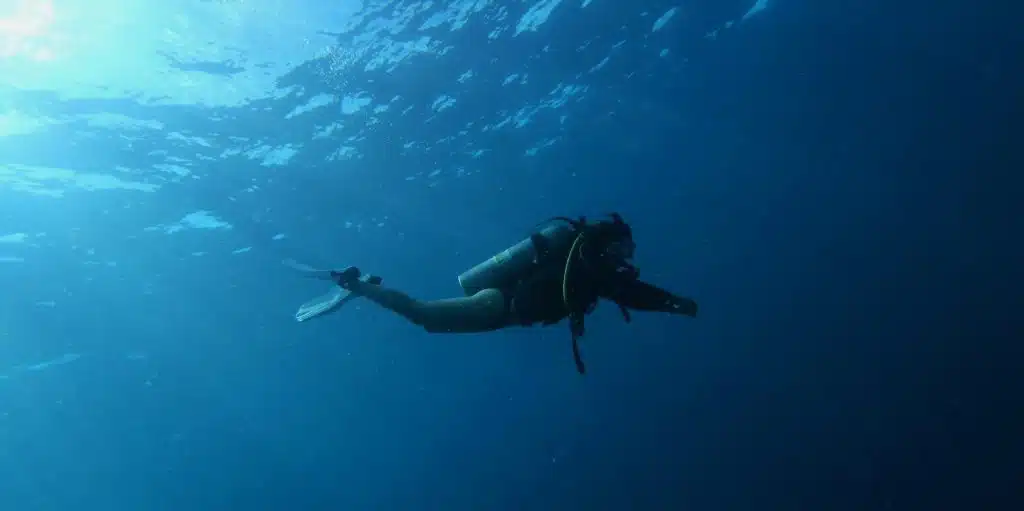 Scuba diver swimming in clear blue water during diving course in Bali