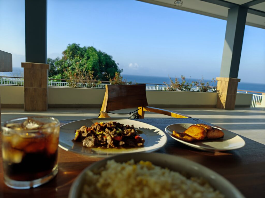 Breakfast table with plated meal and ocean view at Jukung Dive Nusa Penida