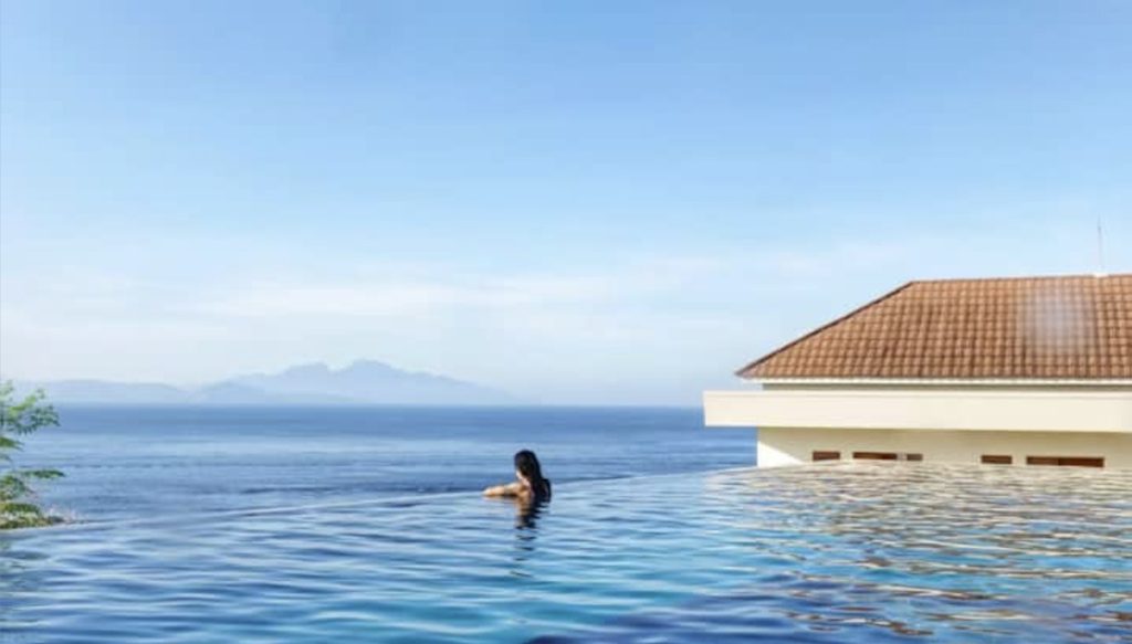 Infinity pool overlooking the ocean at Sky Penida with guest swimming
