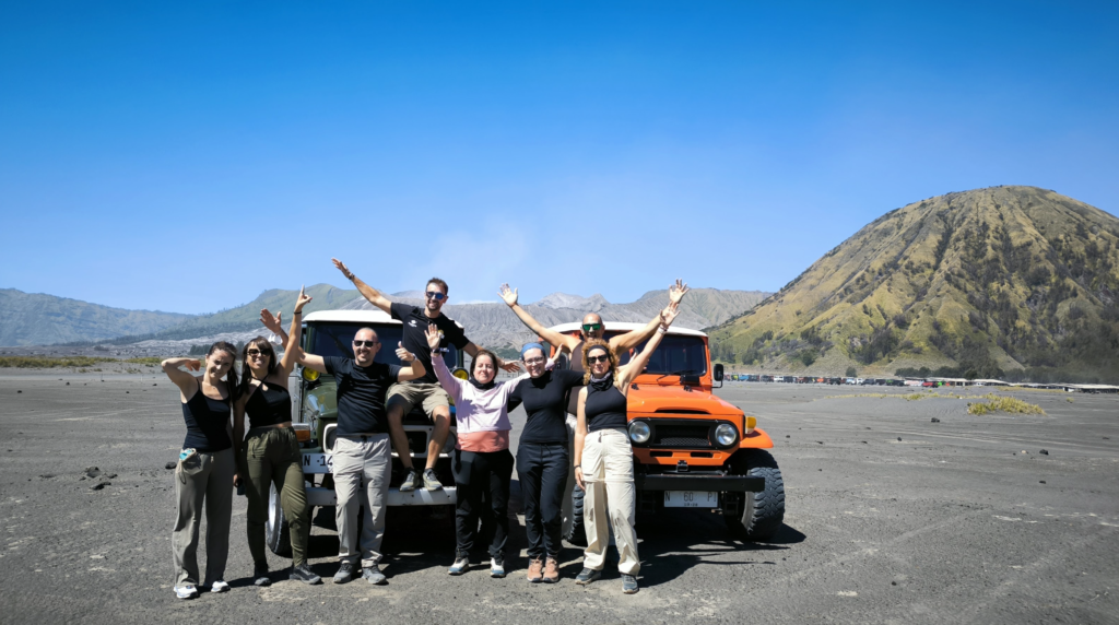 Visitors standing beside jeep at Mount Bromo volcanic landscape, Indonesia
