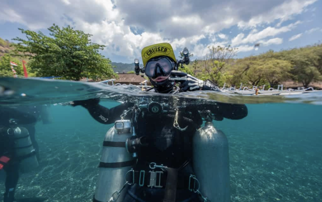 Scuba diver entering the water for a shore dive in Amed Bali Indonesia