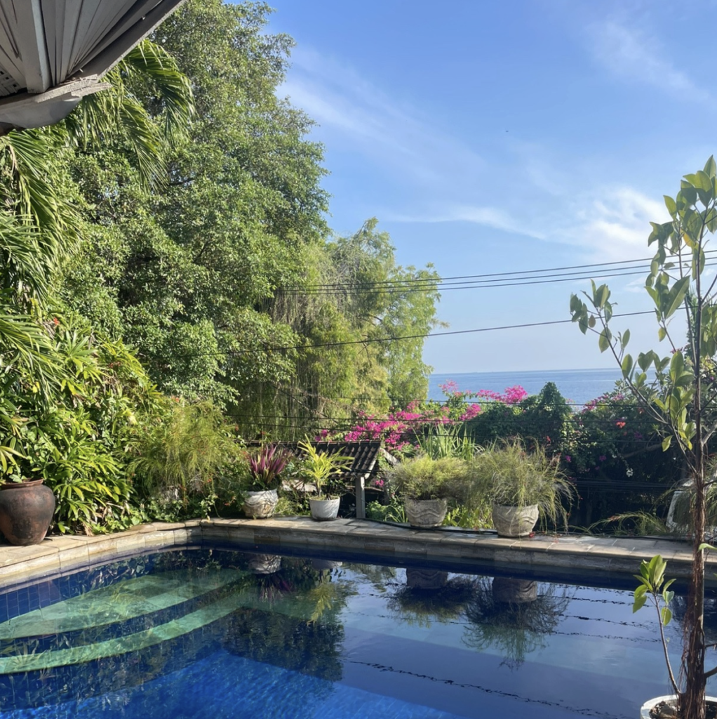 Tropical swimming pool surrounded by gardens at Jukung Dive Amed Resort