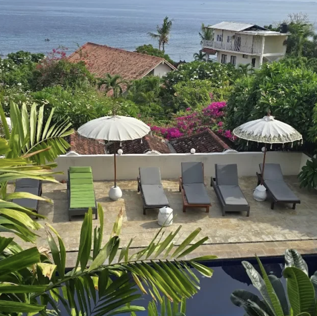 Sun loungers and tropical gardens at Jukung Dive Amed Resort Bali