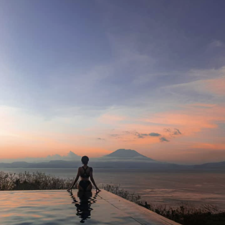 Infinity pool overlooking Mount Agung at sunset in Nusa Penida