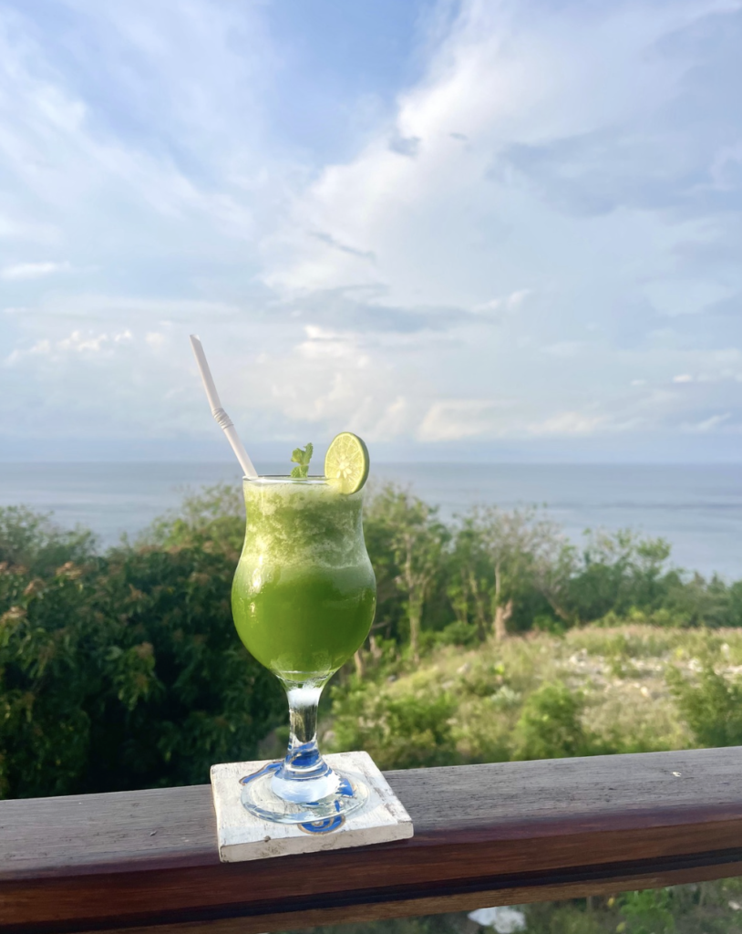 Fresh tropical welcome drink served at Sky Penida Rooftop Restaurant with panoramic ocean views overlooking Nusa Penida and Mount Agung, Bali.