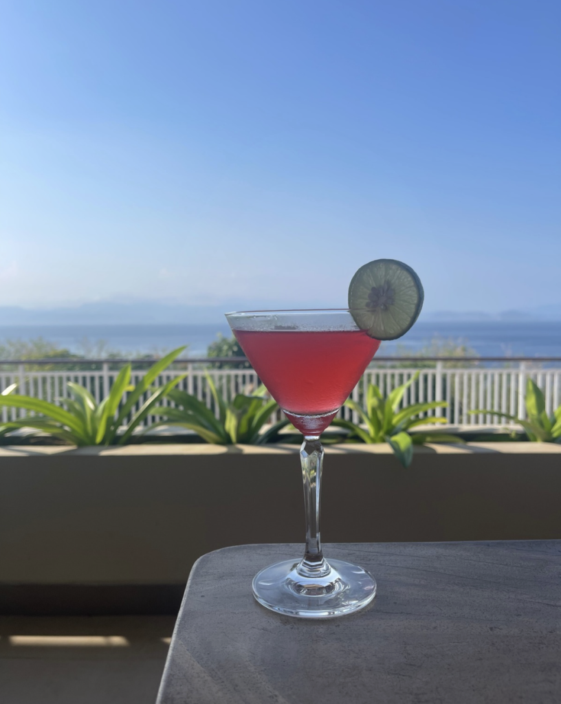 Signature sunset cocktail served at Sky Penida Rooftop Restaurant with panoramic sea views in Nusa Penida, Bali.