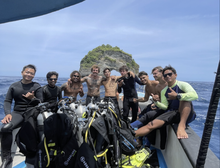 Happy scuba diving group with Jukung Dive Resort on a dive boat in Nusa Penida, Bali before exploring world-class dive sites