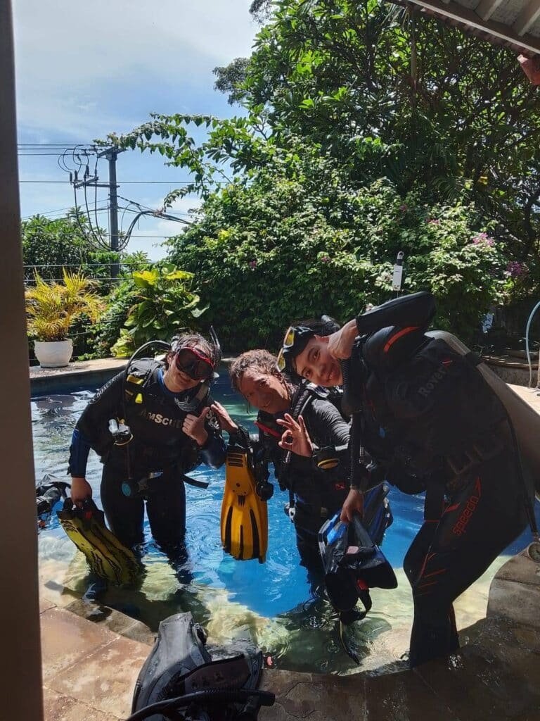 Jukung Dive Bali team members preparing scuba diving equipment outdoors in Amed.